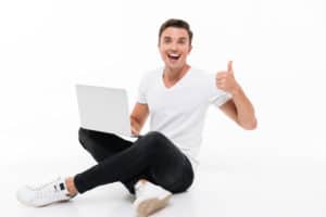 Portrait of a happy excited man holding laptop computer